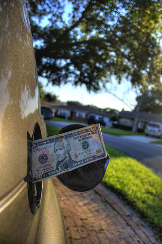 a twenty dollar bill sticking out of a car's gas tank
