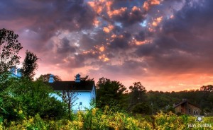 striking celestial sunset, with small house in lower corner